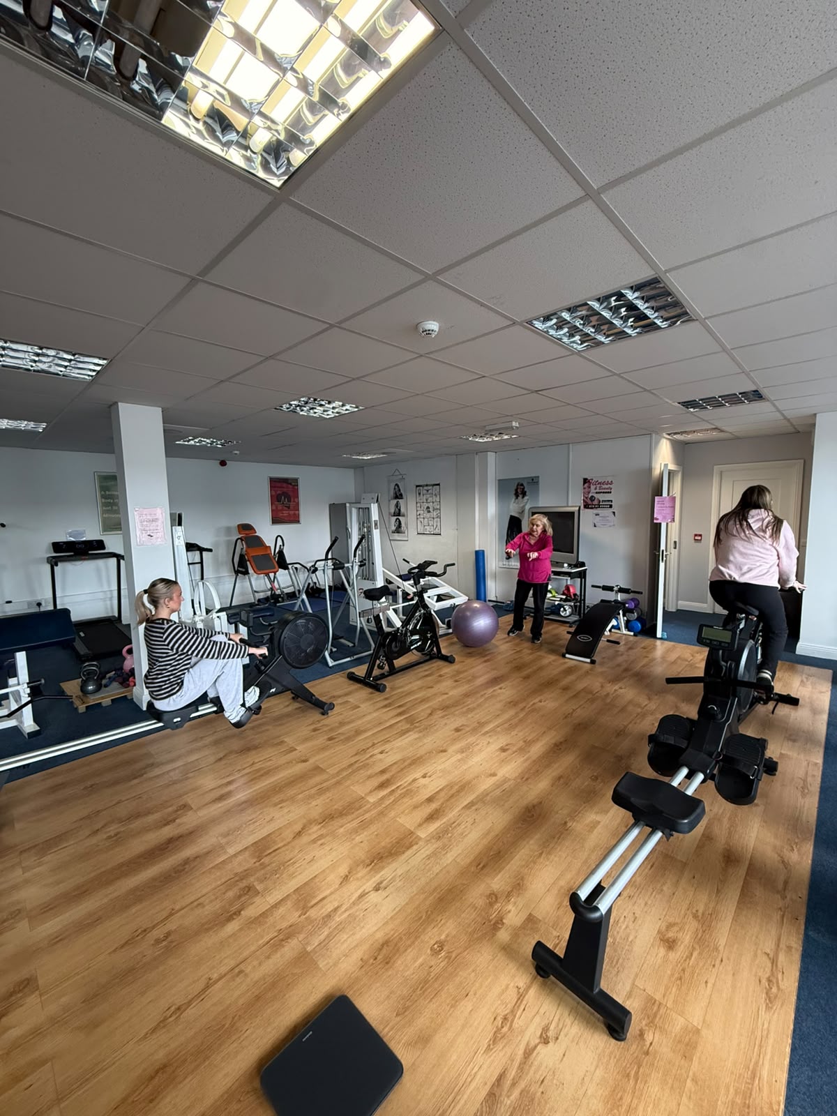 Members on the rowing machine and exercise bike during a coached session